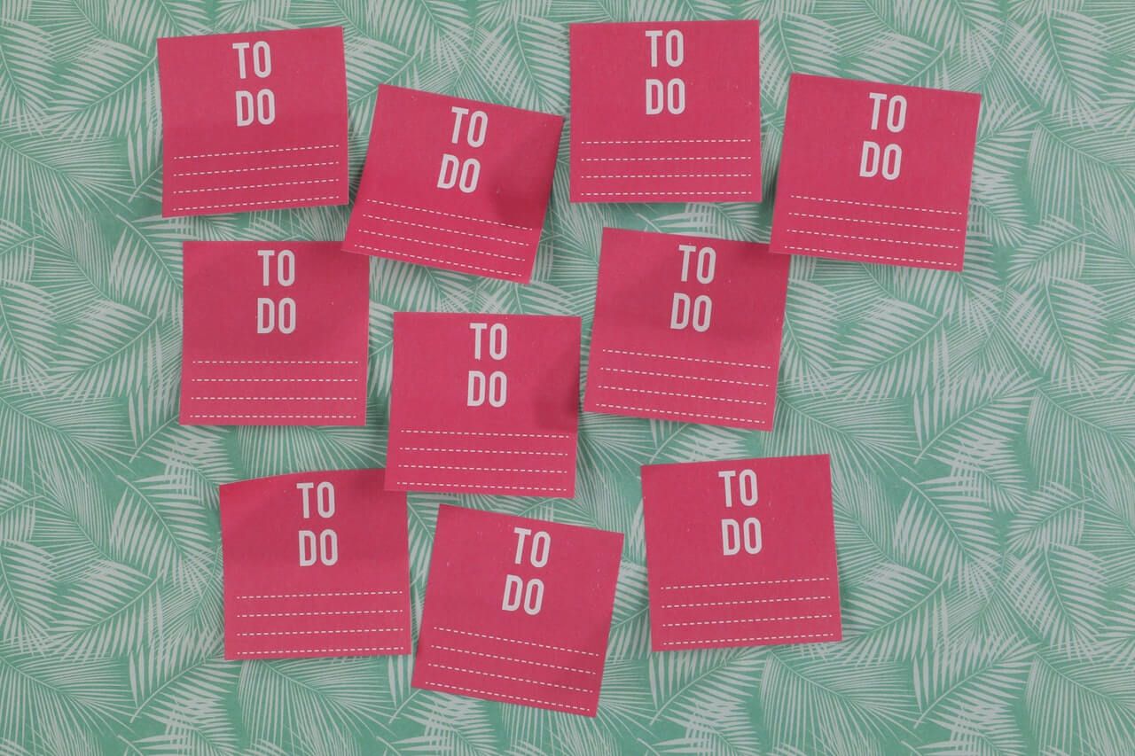 Red post-its with 'to do' written on them against a leafy wall