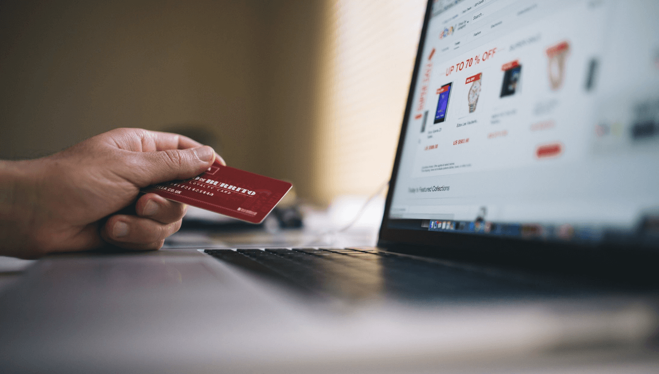 Hand holding credit card, laptop open to eBay's website