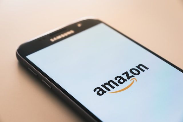 Phone with white background and the Amazon logo on the screen