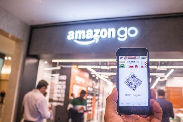 Amazon Go shop front with a person holding a phone in front