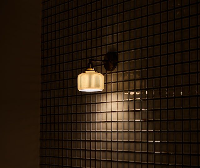 Photo by Will Cook on Unsplash of a wall lamp on a tiled wall